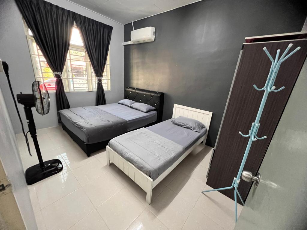 a bedroom with two beds and a shower in it at 2 Bedroom house with Coway, all room air-cond, WIFI, Nettflix in Kampung Gurun