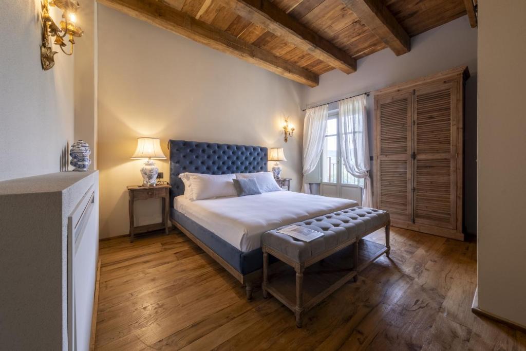 a bedroom with a king sized bed and a wooden floor at Tenuta Bussia - Wine Relais & Spa in Monforte dʼAlba