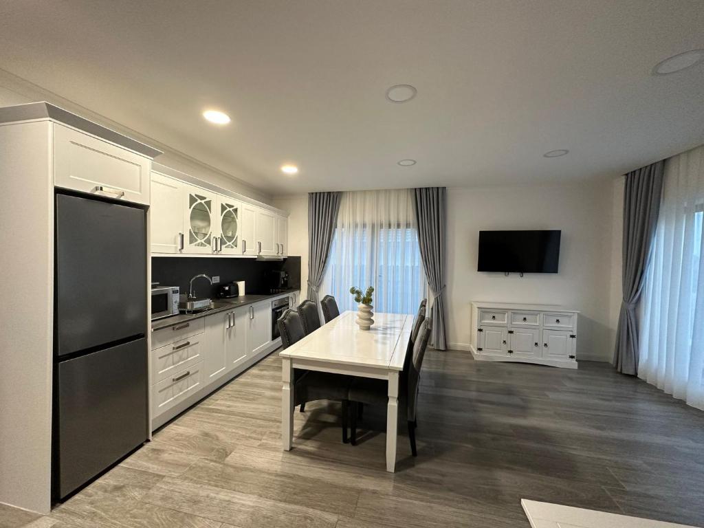 a large kitchen with a table and a refrigerator at M&S Apartament 1 in Baile Felix