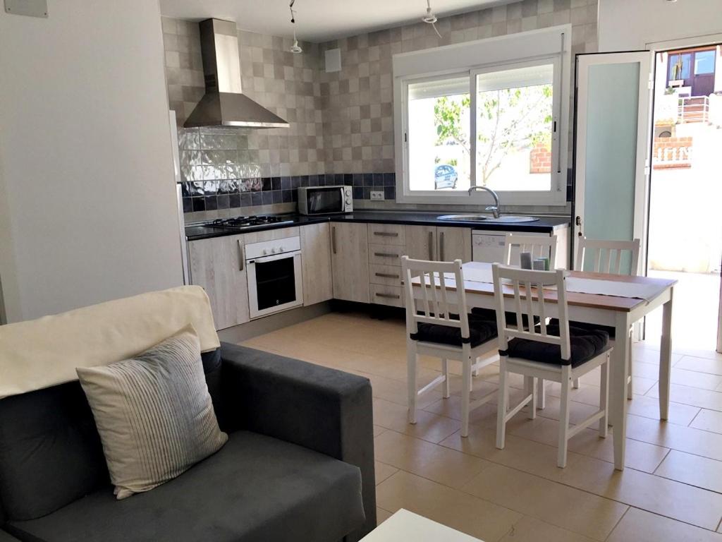 Il comprend une cuisine et un salon avec une table et un canapé. dans l'établissement Casa Iris, à Conil de la Frontera