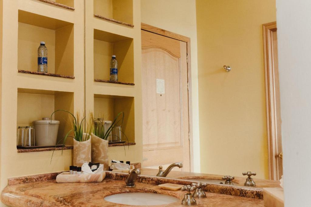 a bathroom with a sink and a large mirror at Gran Hotel de Querétaro in Querétaro