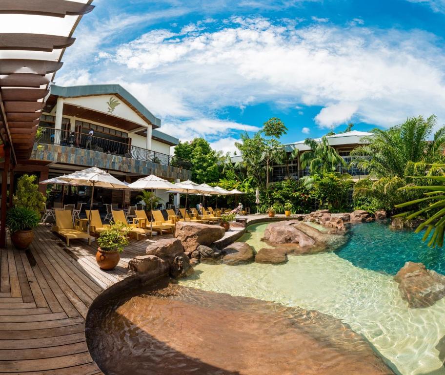 einen Pool in einem Resort mit Stühlen und Tischen in der Unterkunft Jacana Amazon Wellness Resort in Paramaribo