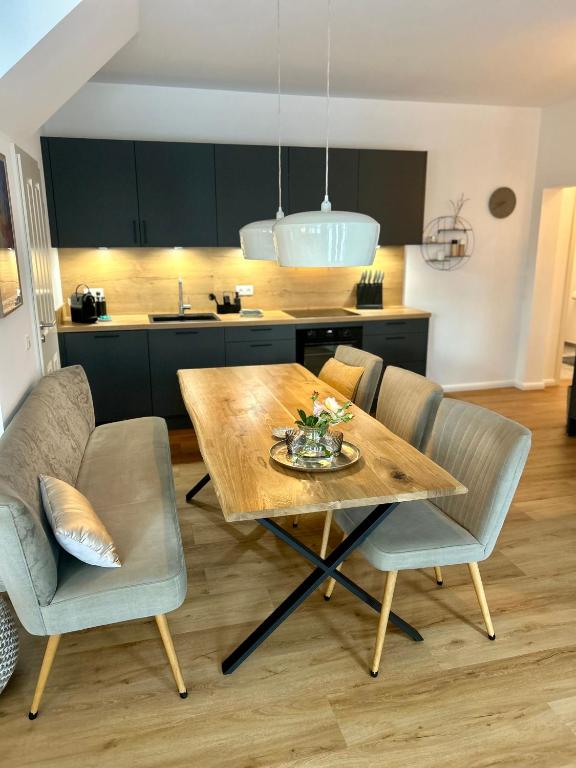 a dining room table with chairs and a kitchen at Noorden Stuuv in Wittenborn