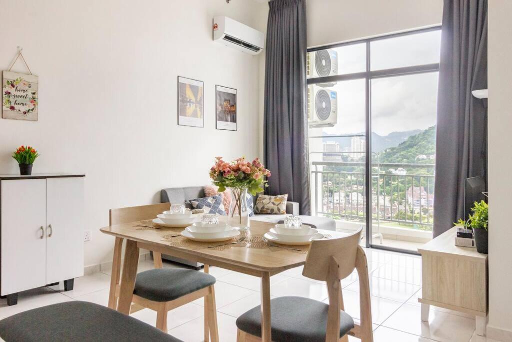 a dining room with a table with chairs and a window at Very fancy strategic suites in Bayan Lepas