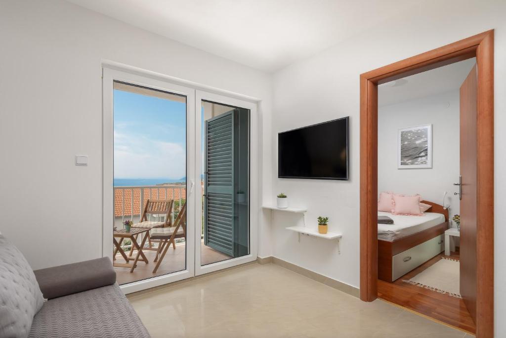 sypialnia z łóżkiem i widokiem na balkon w obiekcie Maki Apartments w Hvarze