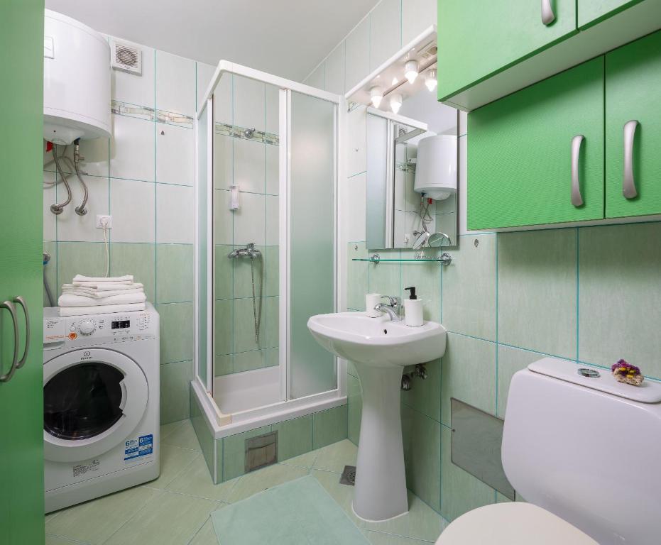 łazienka z pralką, pralką i suszarką w obiekcie Maki Apartments w Hvarze