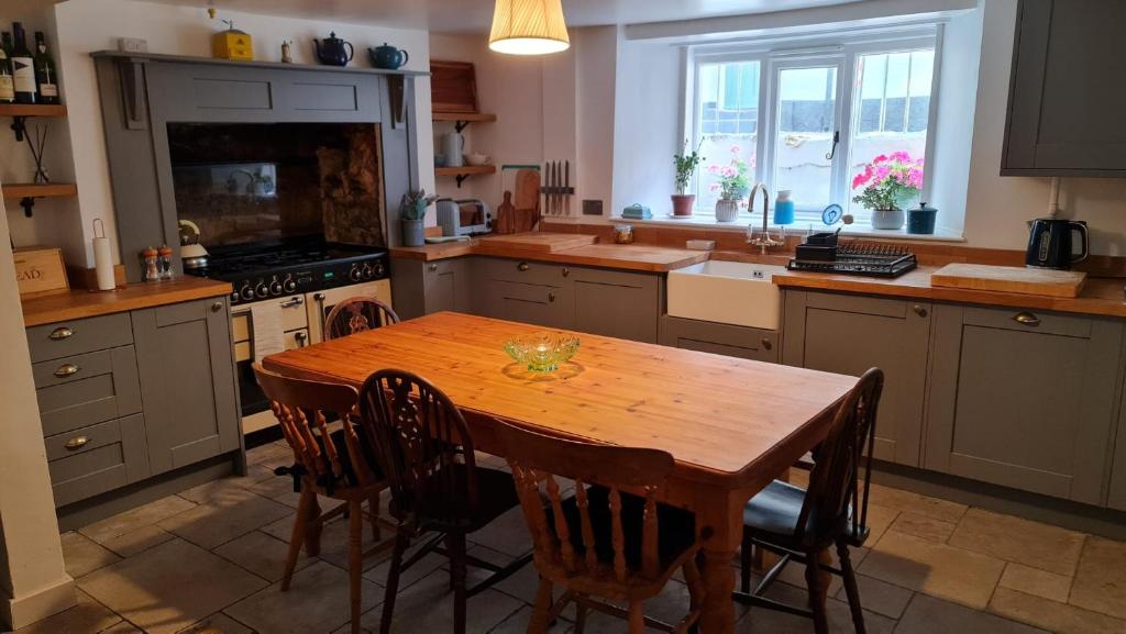 a kitchen with a wooden table and some chairs at Blue Ensign Cottage in Weymouth