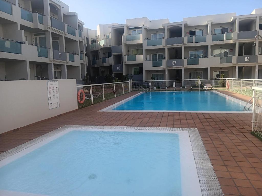 una gran piscina frente a un edificio en GARDEN 128 en Corralejo