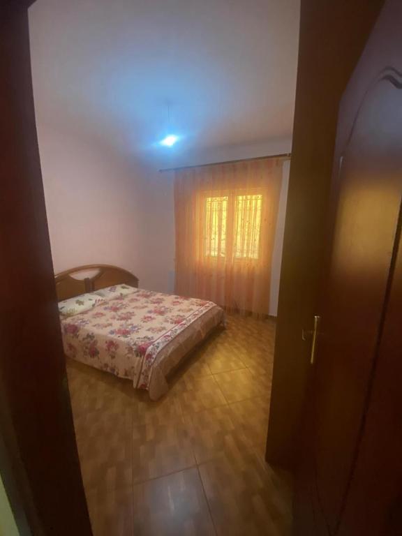 a bedroom with a bed in a room with a window at Mulla Apartment in Sarandë