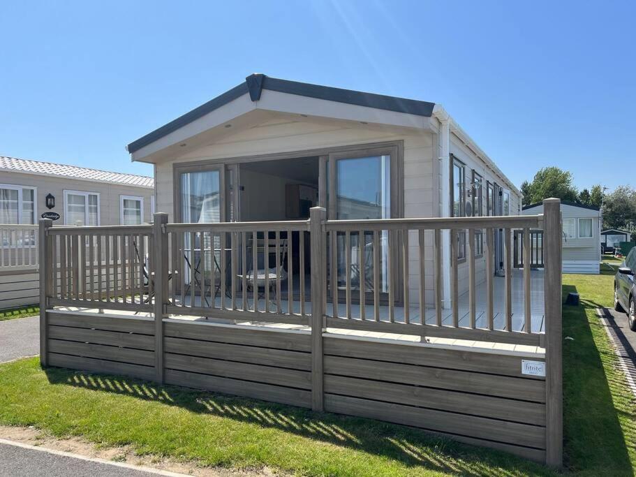 a mobile home with a porch and a deck at Sea view deluxe lodge in Lowestoft