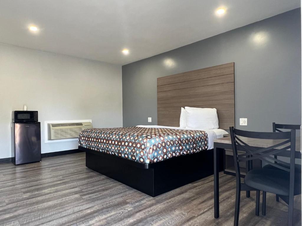 a bedroom with a bed and a table and chairs at Sunshine Motel in Long Beach