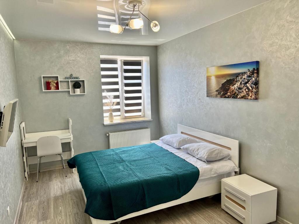um quarto com uma cama, uma mesa e uma janela em Apartment in center premium em Ivano-Frankivsʼk