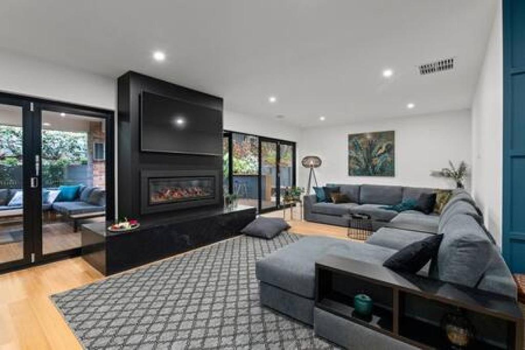 a living room with a couch and a fireplace at BADGER HOUSE - 4 Bed, 4 Bath, Stunning Entertainer plus Fire in Healesville
