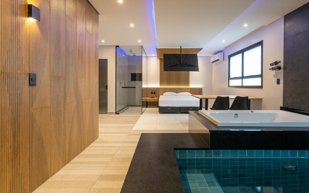 uma casa de banho com banheira e um quarto em Drops Motel POA Zona Sul em Porto Alegre