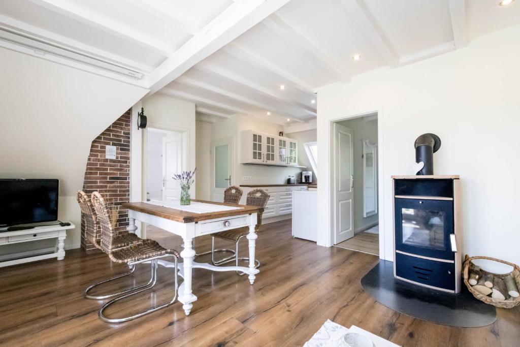 a kitchen and living room with a table and a fireplace at Romantik-Home Nordelsass - Ferienwohnung für Selbstversorger in Oberhoffen-lès-Wissembourg