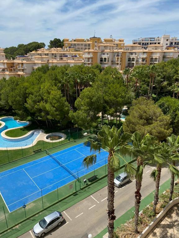 an overhead view of a tennis court with trees and buildings at Aquamarine home in Campoamor