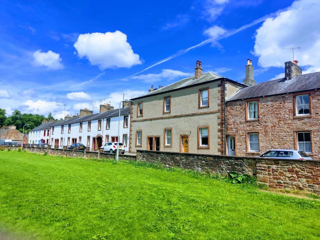 a row of houses on a green field at Eden house in Appleby