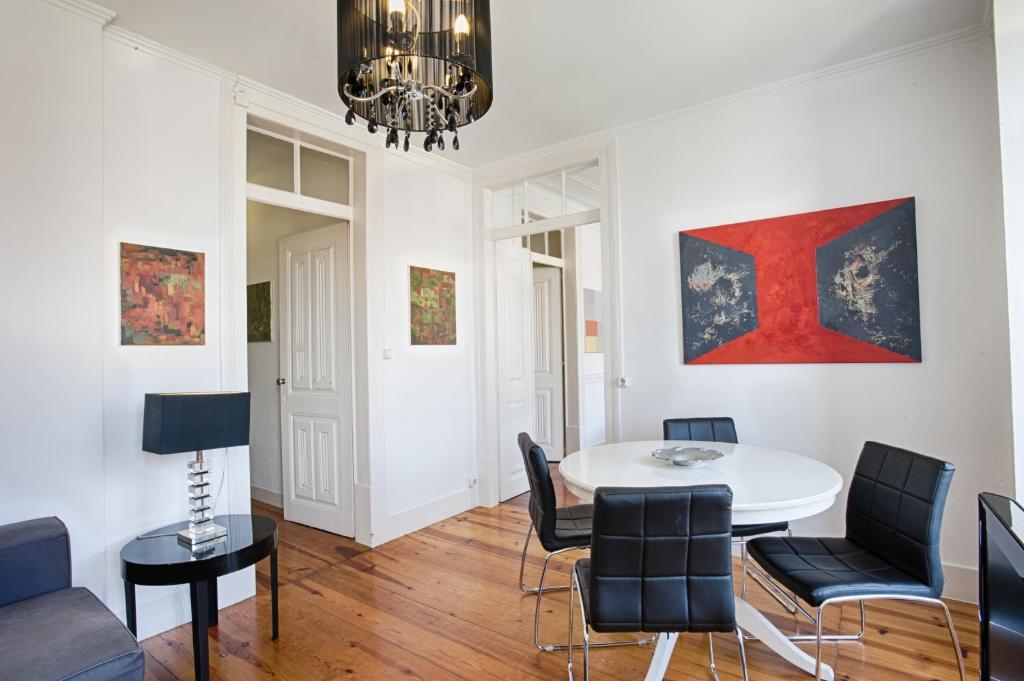 リスボンにあるBmyGuest - Príncipe Real Galeria Apartmentのリビングルーム(テーブル、椅子付)