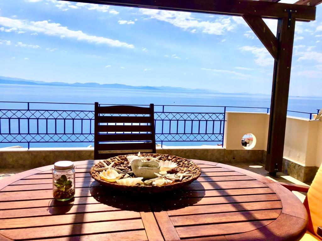 una mesa de madera con un plato de comida en el balcón en ΑquaView, en Gythio