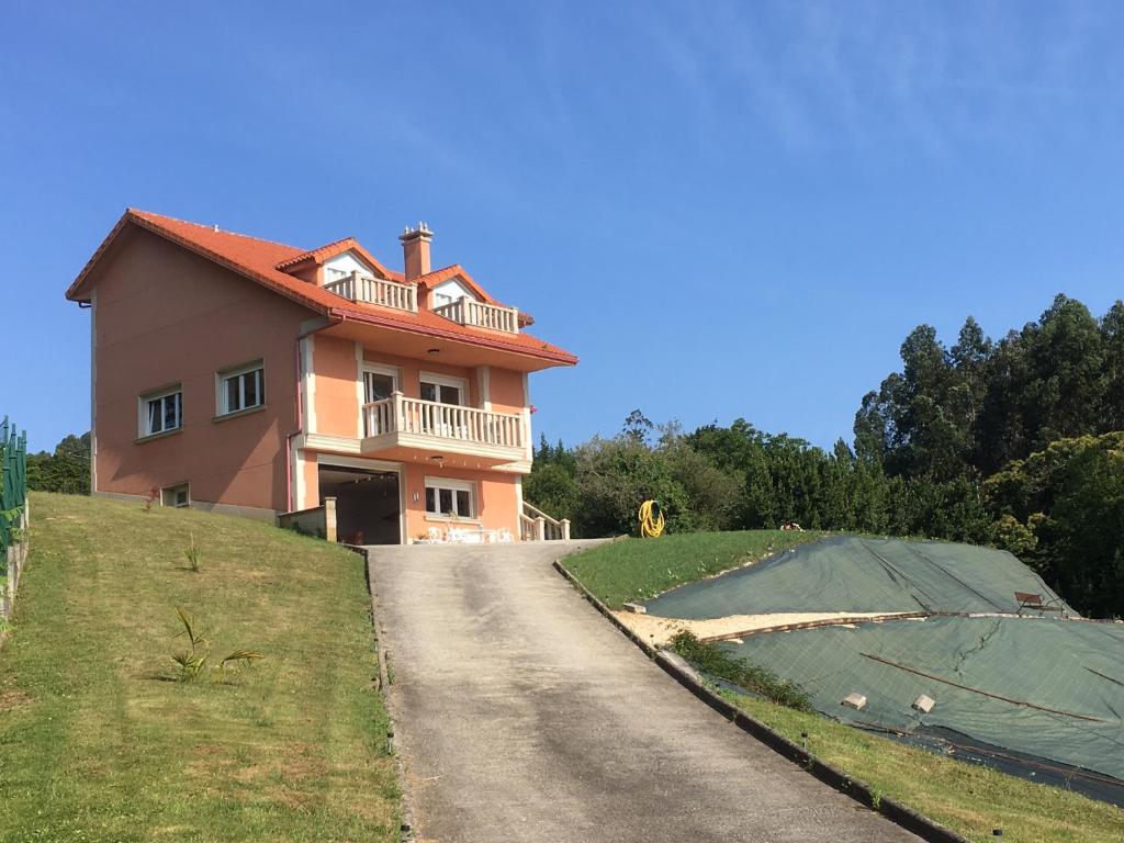 una casa en la cima de una colina con una carretera en CASA FONTE DA PEDREIRA, en Sada