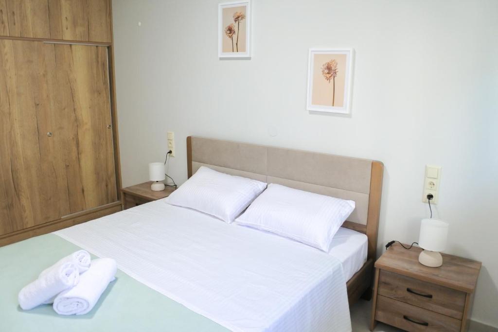 a bedroom with a bed with white sheets and towels at Maison Nikola Kanali in Kanali