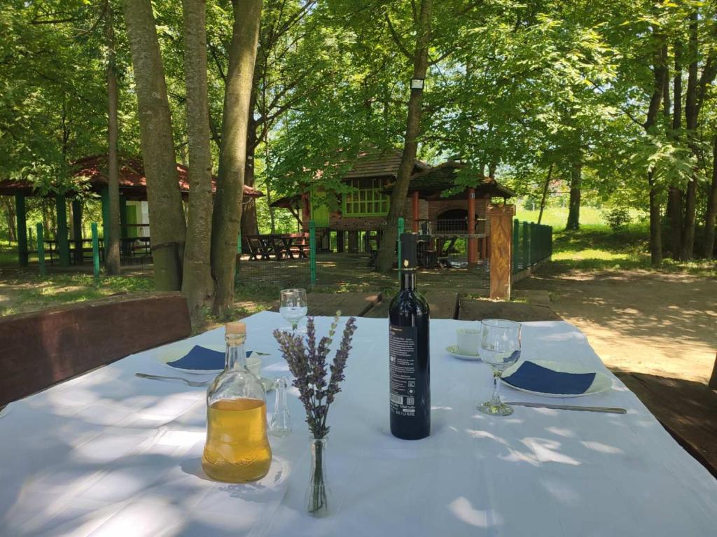 una mesa con una botella de vino y copas. en Kutak na Drini en Mali Zvornik