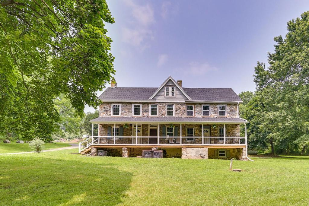 una casa grande en un campo verde con árboles en Spacious Country Home in Coatesville on Old Ranch!, en Coatesville