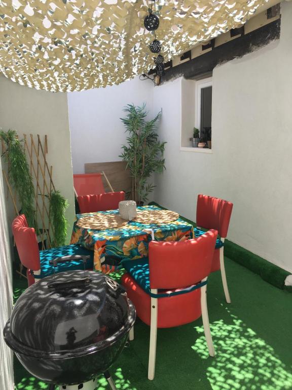 een tafel en stoelen in een kamer met een tafel bij Cosy avec patio en bord de lac in Istres