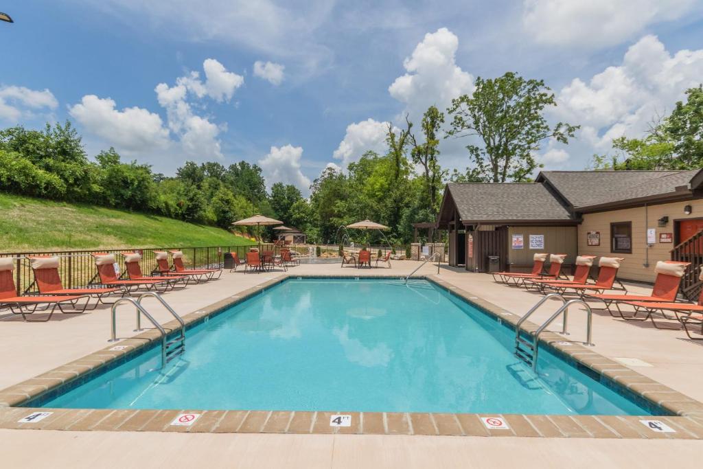 a pool at a resort with chairs and tables at NEW 3 BR Apartment Sleeps 6 in Pigeon Forge