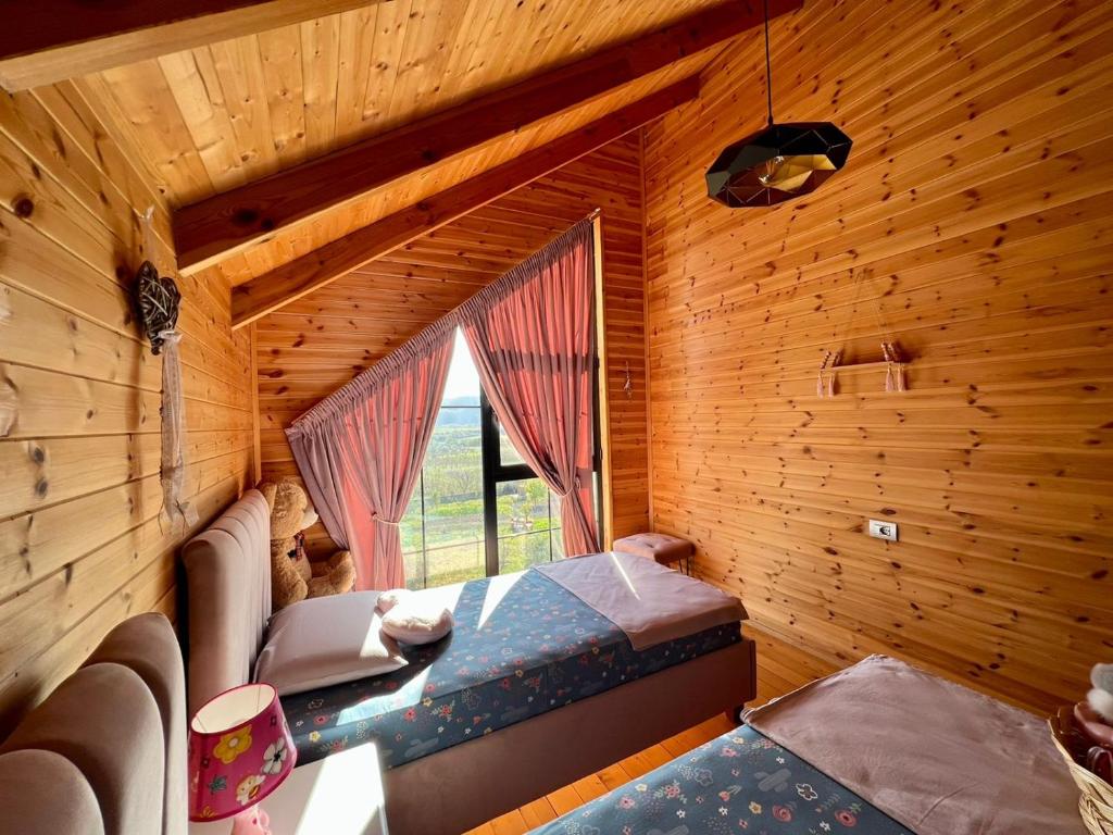 a bedroom in a log cabin with a bed and a window at Villa Kei 