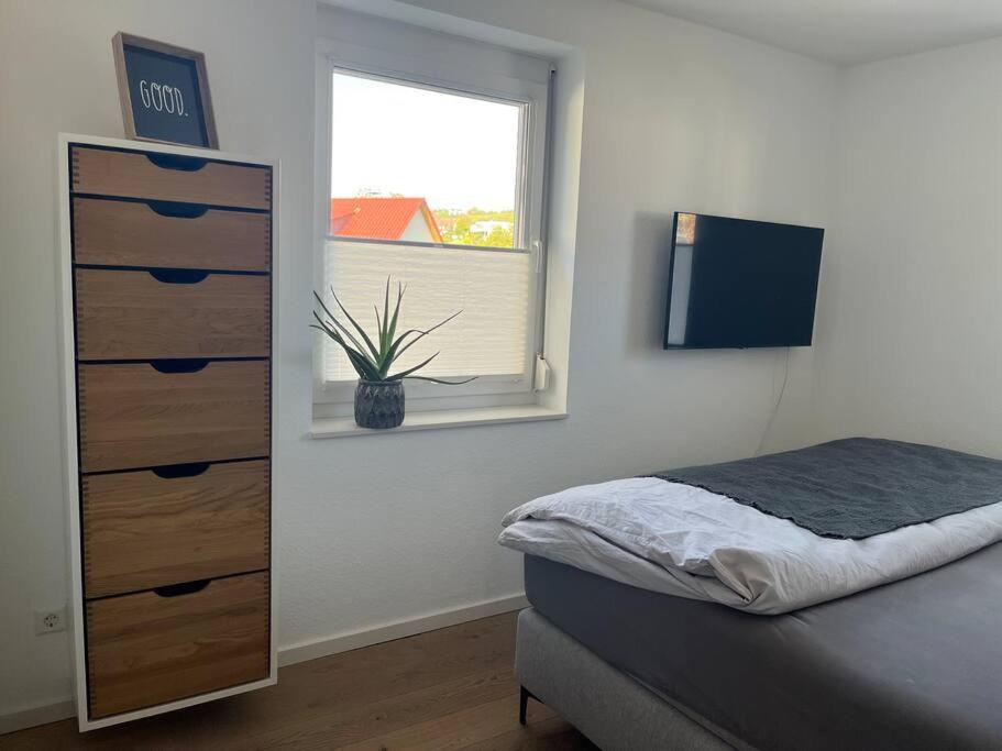 1 dormitorio con 1 cama, vestidor y ventana en Stadtvilla am Park Heilbronn Pfühlpark, en Heilbronn