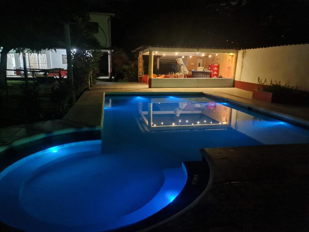ein Schwimmbad in der Nacht mit blauen Lichtern darin in der Unterkunft Chalet El Paraiso in Escuintla