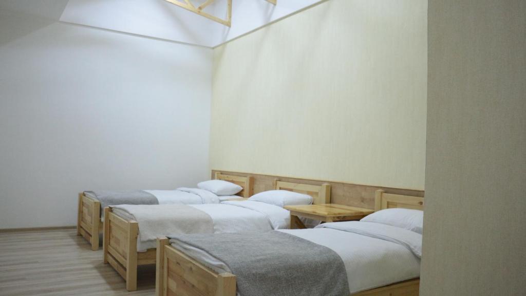 a group of four beds in a room at 21 Rooms Hotel in Gyumri