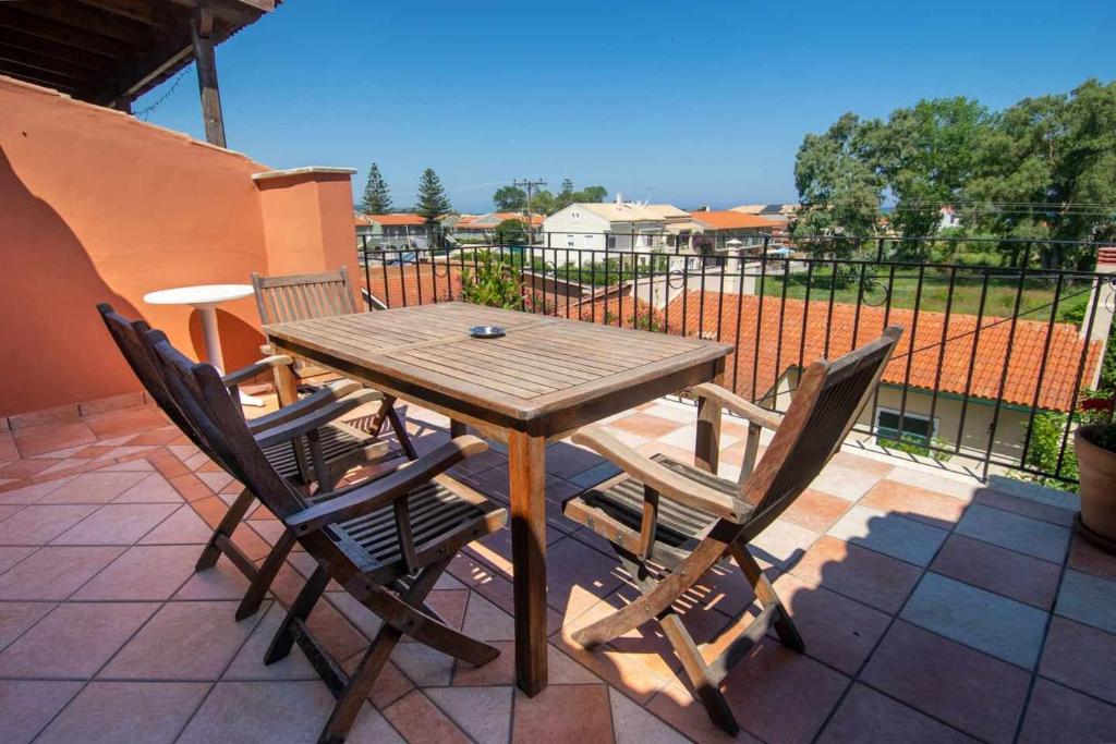 Fotios Roof apartment في أكارافي: طاولة وكراسي خشبية على الفناء