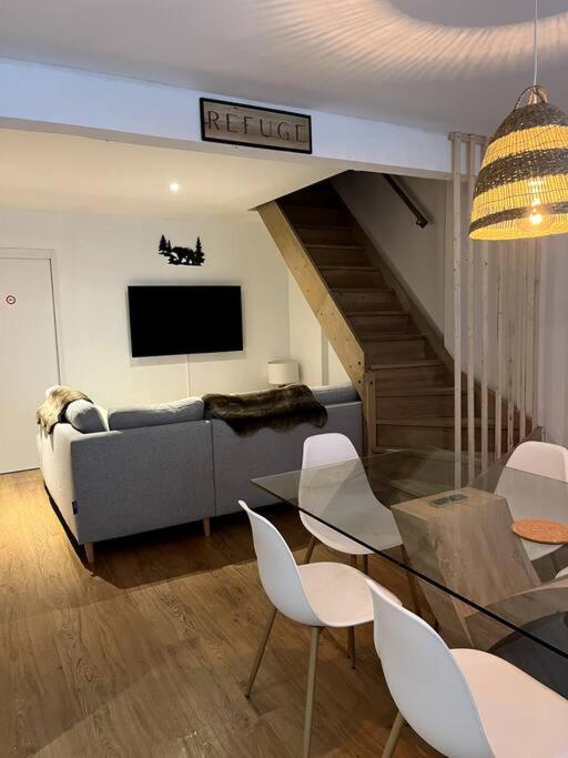 a living room with a couch and a table and chairs at Un doux refuge in Soldeu lʼHospitalet