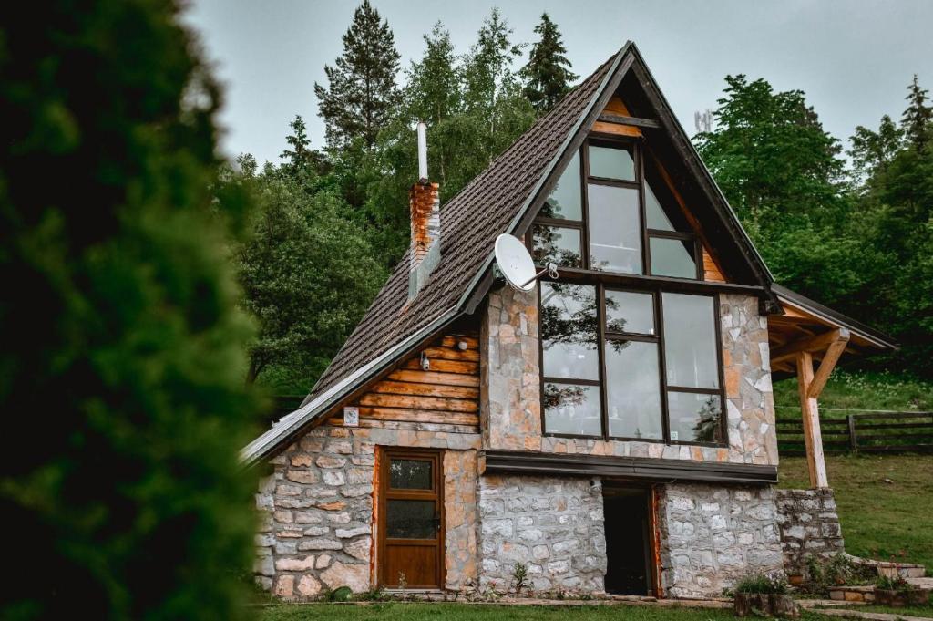 a cabin with a gambrel roof and windows at Planinska Koliba ABA-TARA in Bajina Bašta