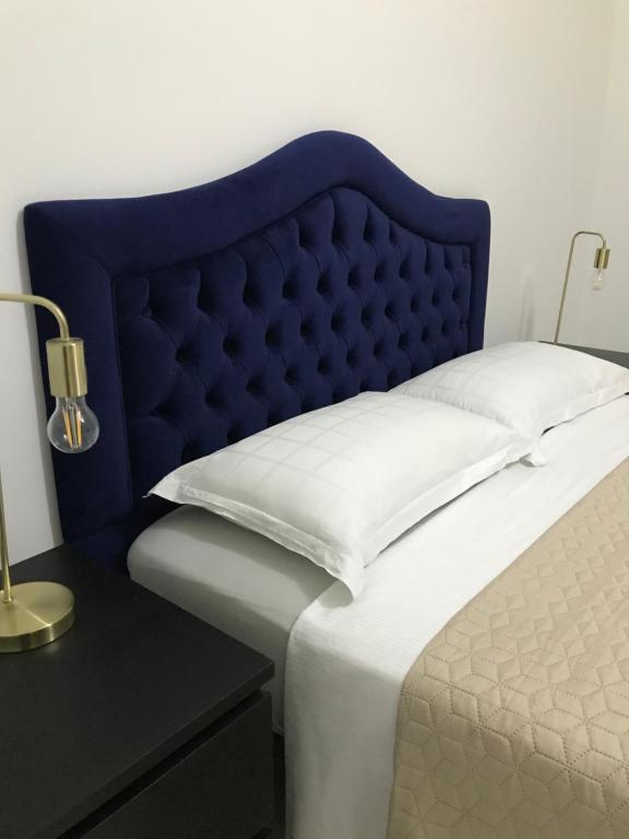 a bed with a blue headboard next to a table at résidence les oliviers in Soliman