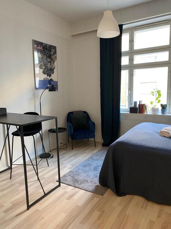 a bedroom with a bed and a desk and a window at Wonder studio apartment prime location and commute in the heart of Kallio in Helsinki