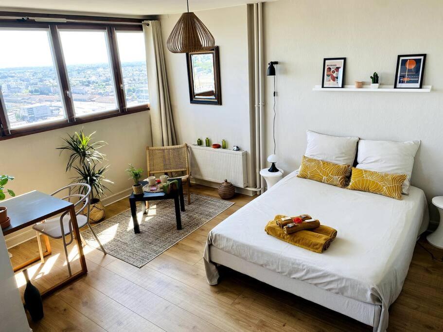 une chambre avec un lit, une table et un bureau dans l'établissement Le Cassiopée - Vue incroyable surplombant Rennes, à Rennes