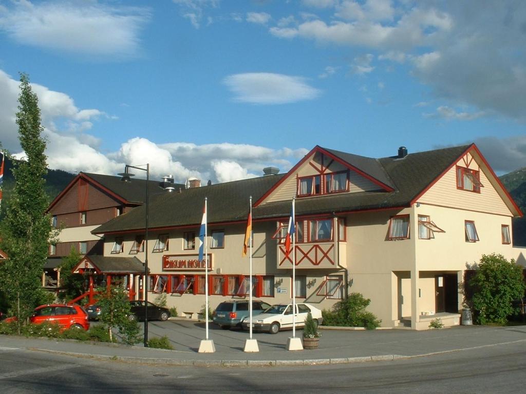 een groot gebouw met auto's geparkeerd voor het bij Eikum Hotel in Hafslo