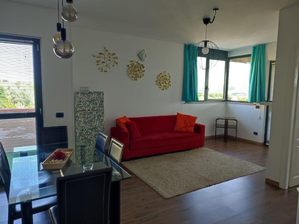 salon z czerwoną kanapą i stołem w obiekcie Villa Giuseppe w mieście Roseto degli Abruzzi
