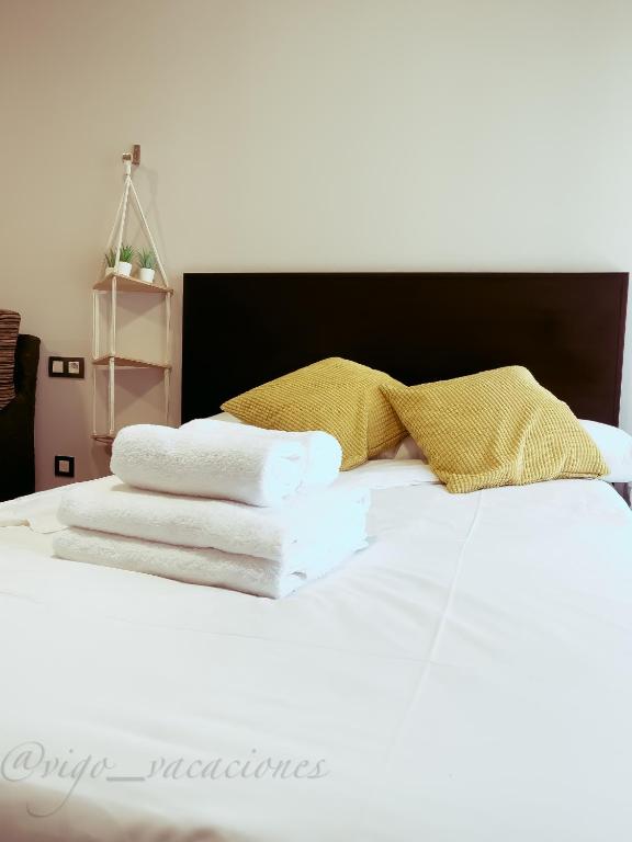 a bed with three towels on top of it at JoaquinLoriga18 By Vigovacaciones in Vigo