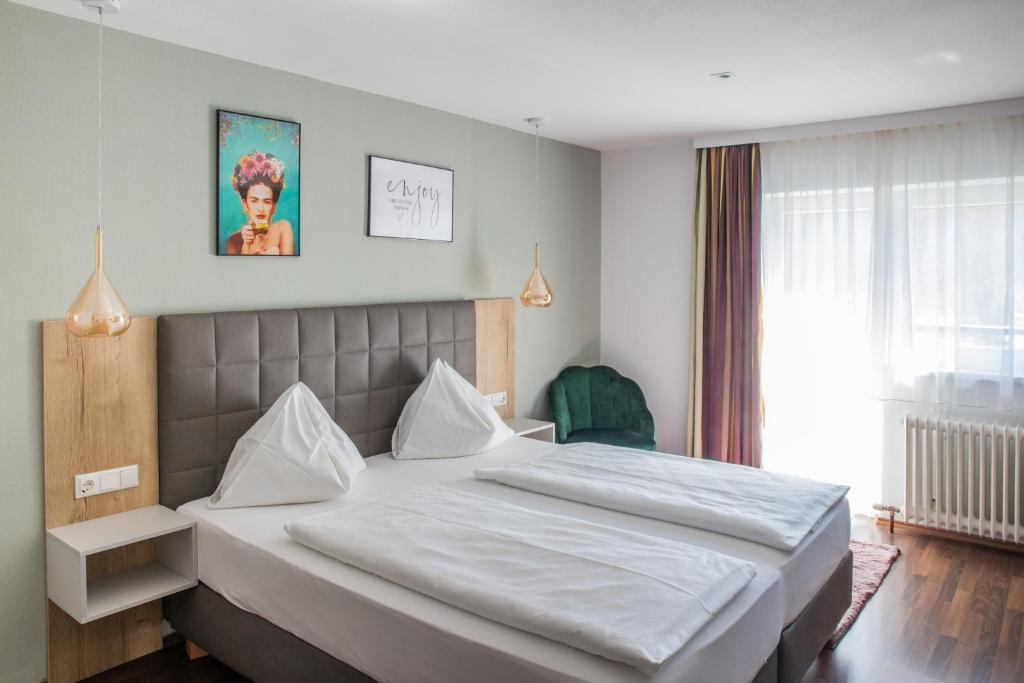 ein Schlafzimmer mit einem großen weißen Bett in einem Zimmer in der Unterkunft Pension Waldesruh in Bad Ischl