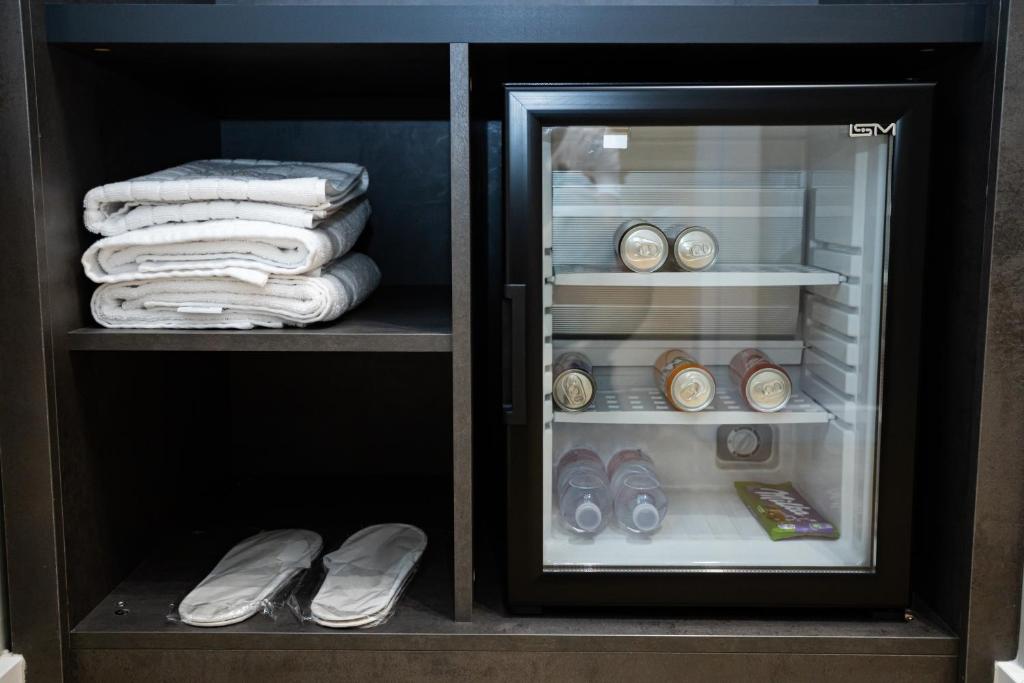 an open refrigerator with towels and clocks in it at Bee Hotel in Vlorë