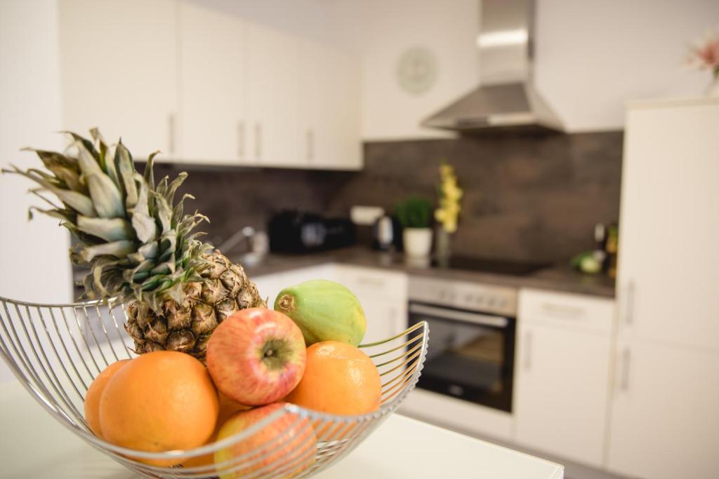 格拉茲的住宿－Apartment Centro - YOUR 2nd HOME in GRAZ，厨房里的柜台上放一碗水果