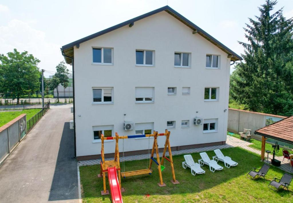 a white building with a playground in front of it at Villa Sara in Sarajevo