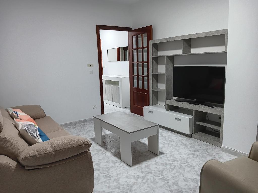 a living room with a couch and a tv and a table at Apartamento RUAL in Sanxenxo