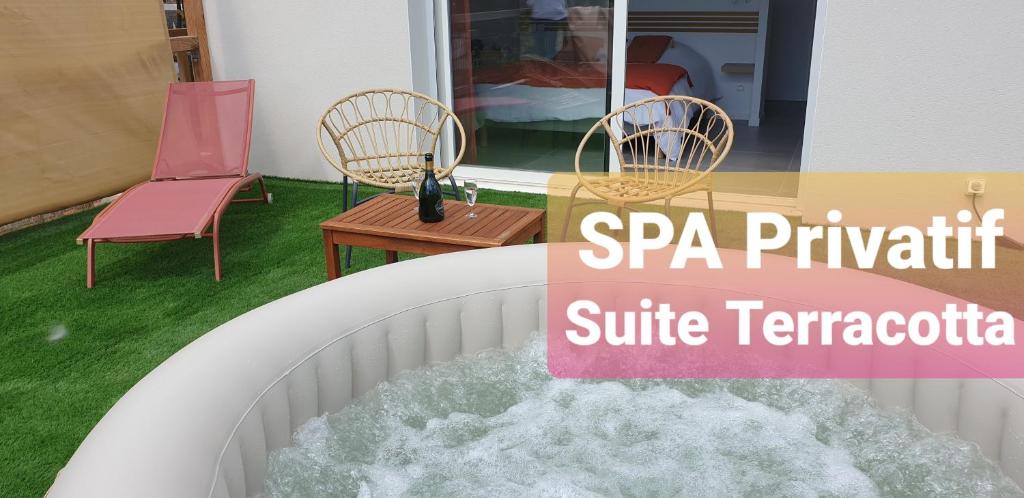 a water fountain with two chairs and a table at Les Suites du XV in Cap d'Agde