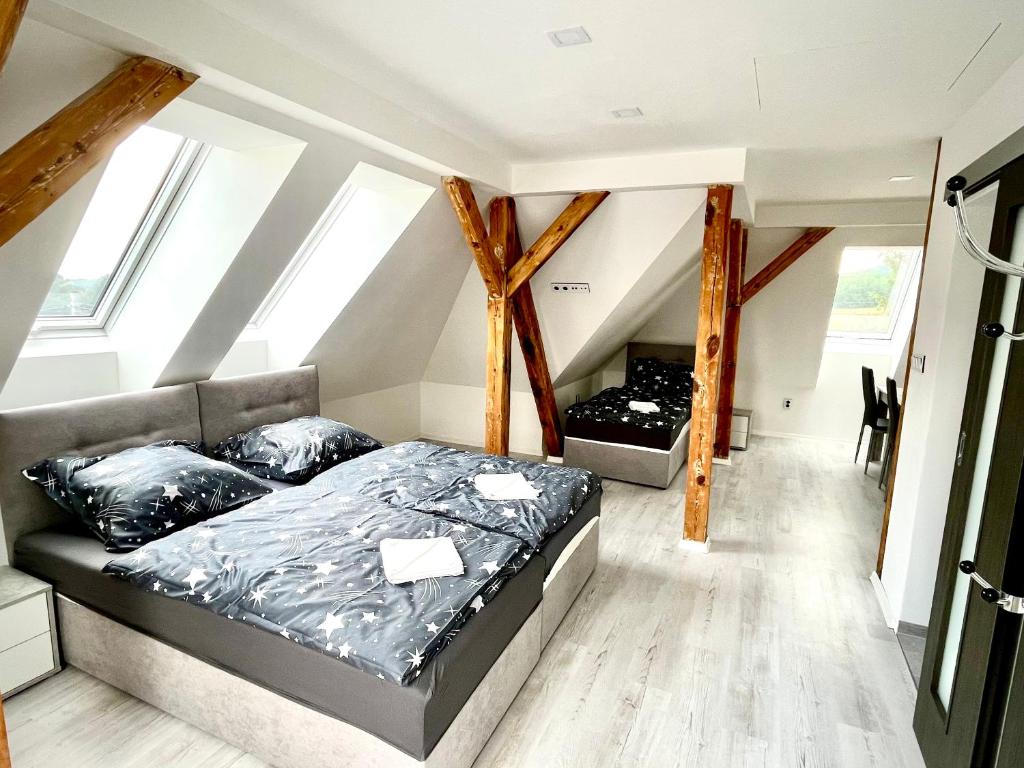 ein Schlafzimmer mit einem Bett im Dachgeschoss in der Unterkunft Apartmány Pihel s parkovaním zdarma 