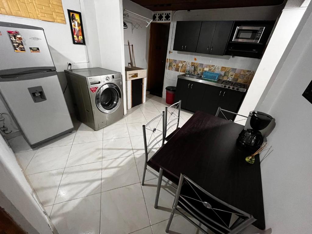 cocina con mesa y lavadora en Aparta Suite Torre De Prado, en Medellín
